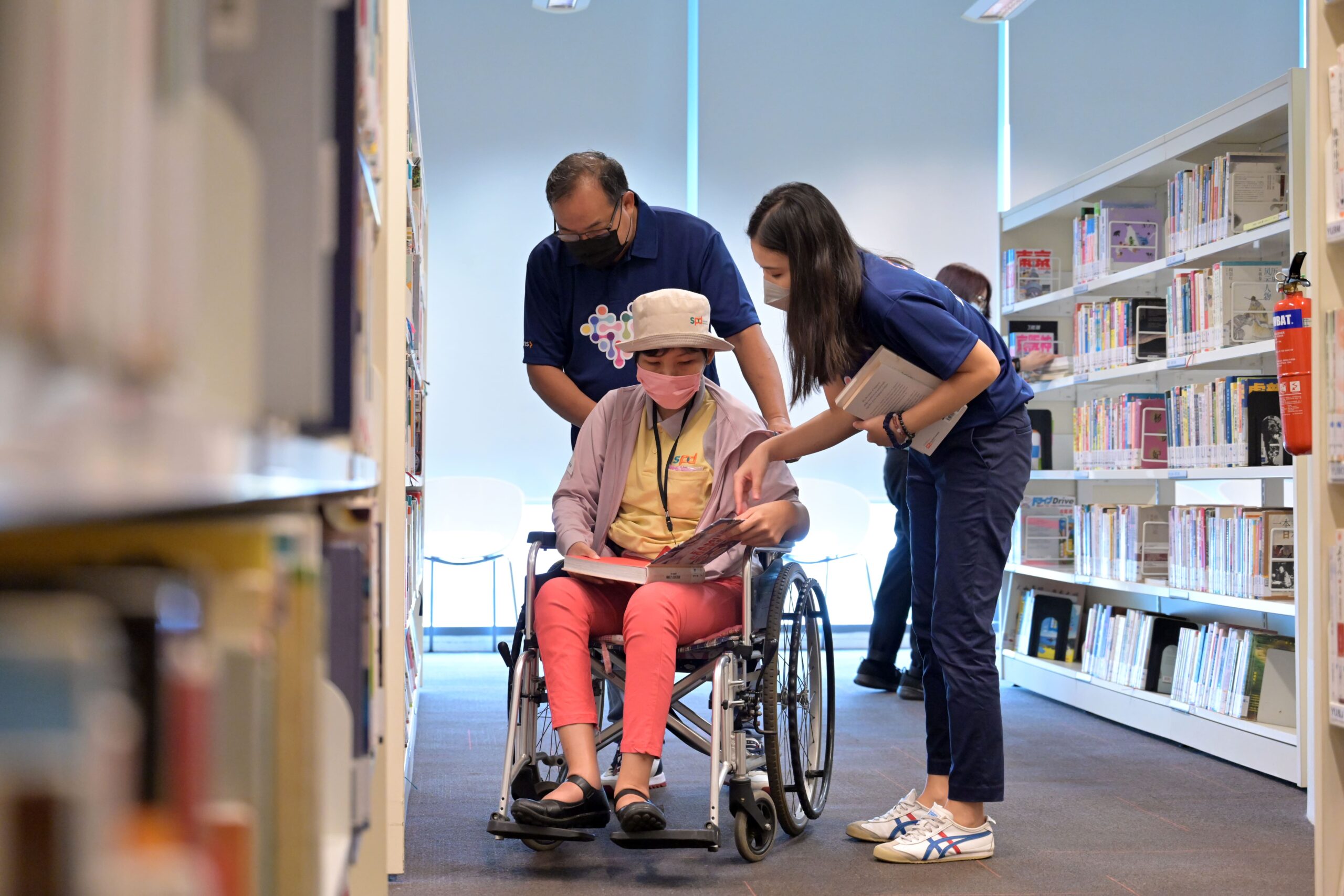 Certis_volunteers_and_SPD_beneficiaries_choosing_books_to_read_together-min